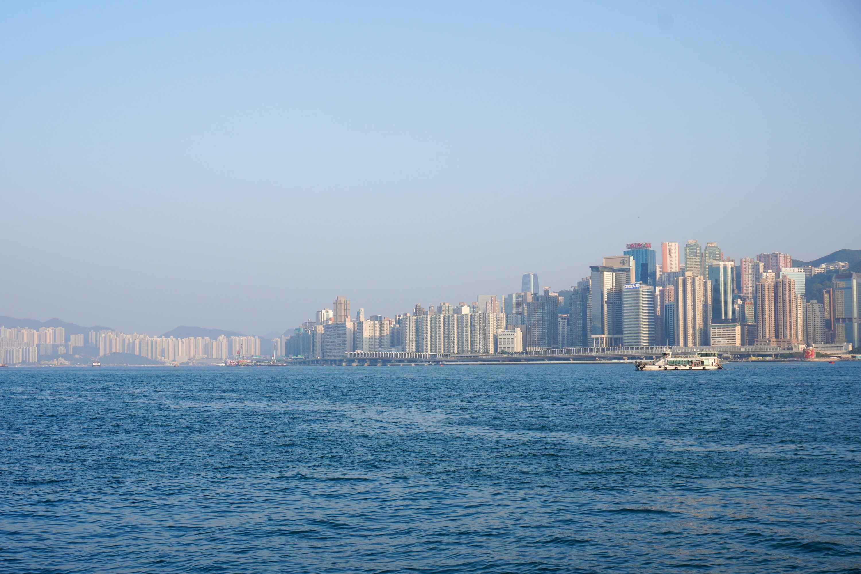Modern cityscape across wide blue ocean